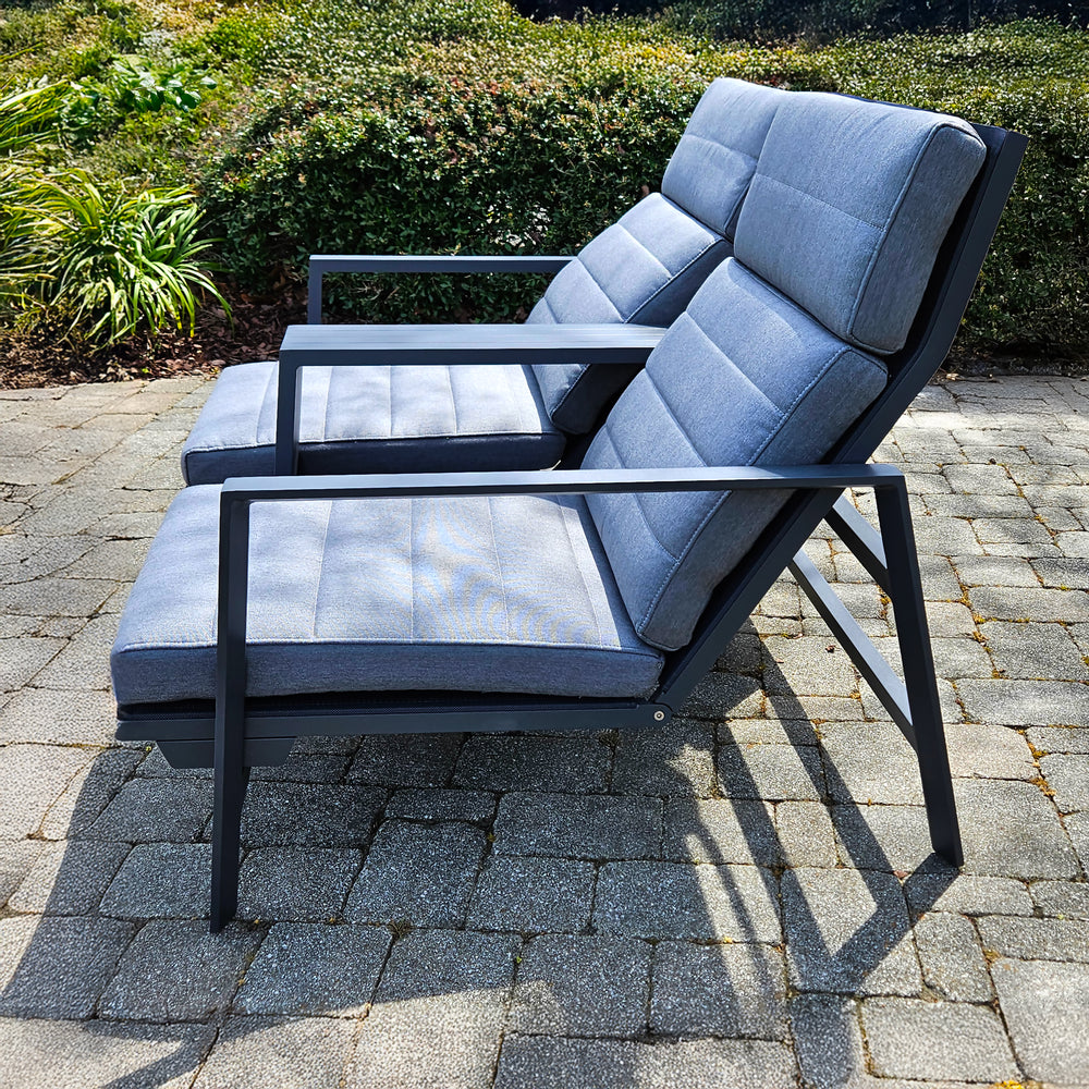 Bondi Tete A Tete Loveseat with reclining backrests, aluminum frame, and soft cushions on a stone patio.