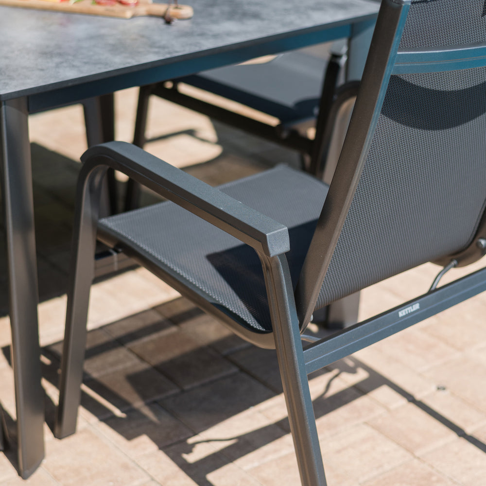 Basic Plus 5-Piece Dining Set with stackable gray chairs and 37" table featuring umbrella hole for outdoor use.