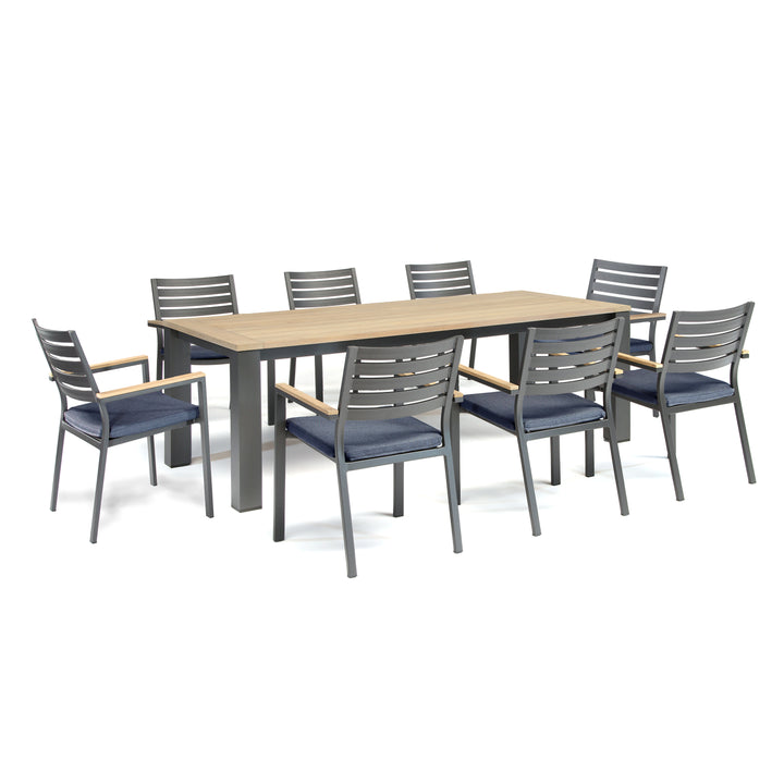 Elba 9-Piece Dining Set with teak tabletop, charcoal aluminum frame, and indigo cushioned stackable chairs.