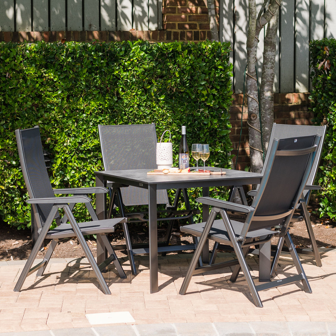 Basic Plus 5-Piece Dining Set with multi-position grey chairs and 37-inch table with umbrella hole outdoors.