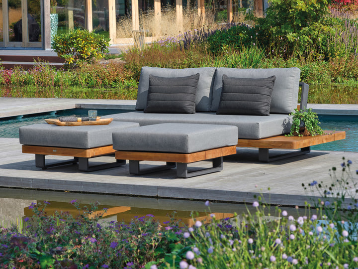 Fitz Roy Teak Sofa with all-weather cushions and teak accents on aluminum frame on outdoor deck by pool.