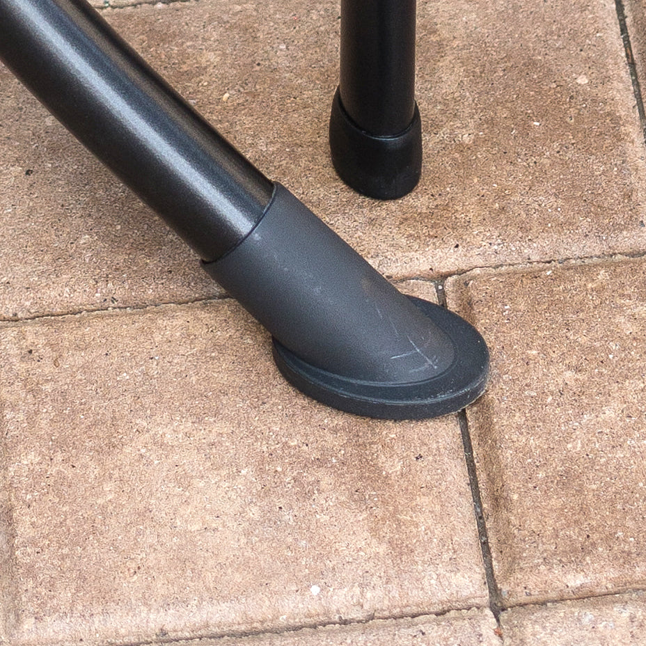 Foot cap on an outdoor table leg and chair leg.