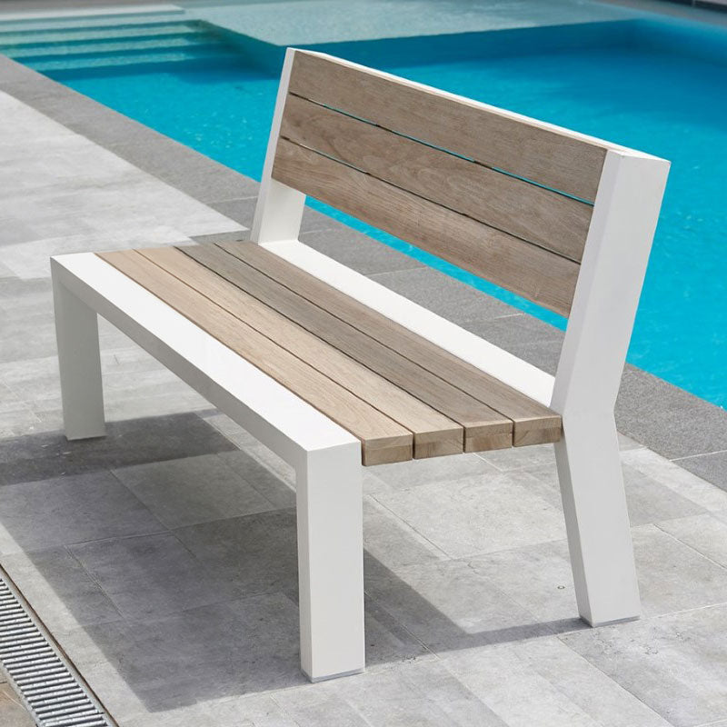 Java Robust Aluminum / Teak Benches with white aluminum frame and grey teak seat by a poolside on stone tiles.