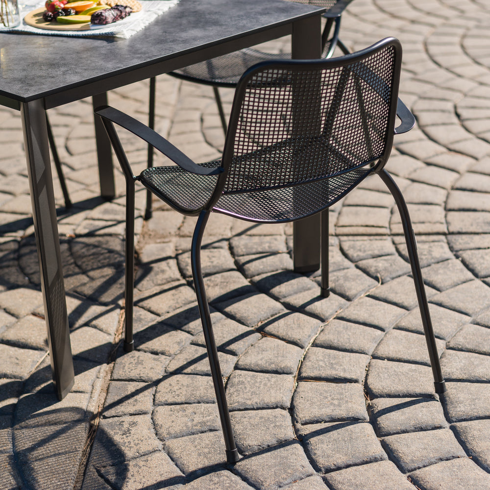 Metro Stacking Arm Chair - Set of 6 featuring curved armrests, steel mesh design, and weather-resistant finish for outdoor use.