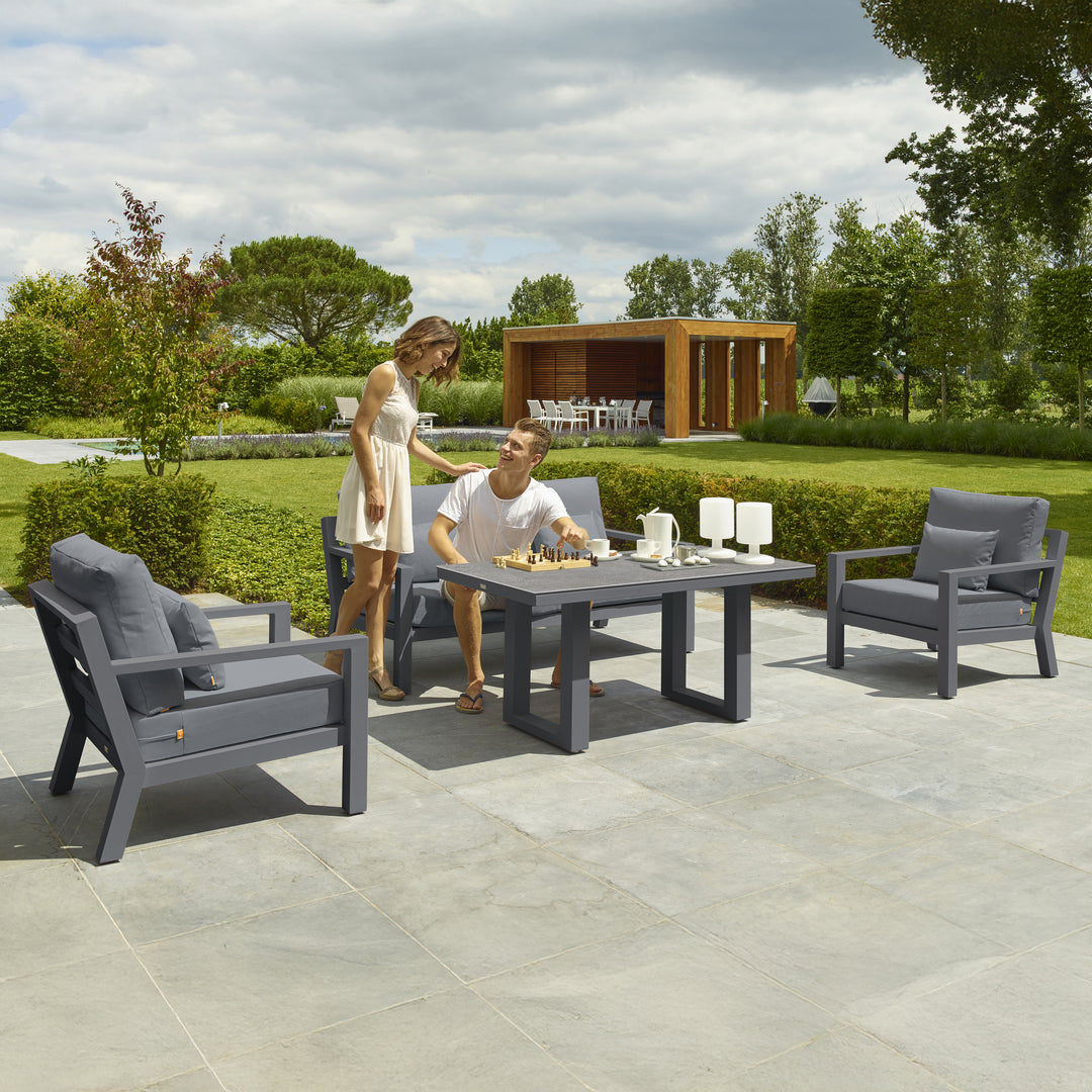 Timber Lounge Set with High Coffee Table in charcoal with deep seating and ceramic top on patio with two people playing chess.