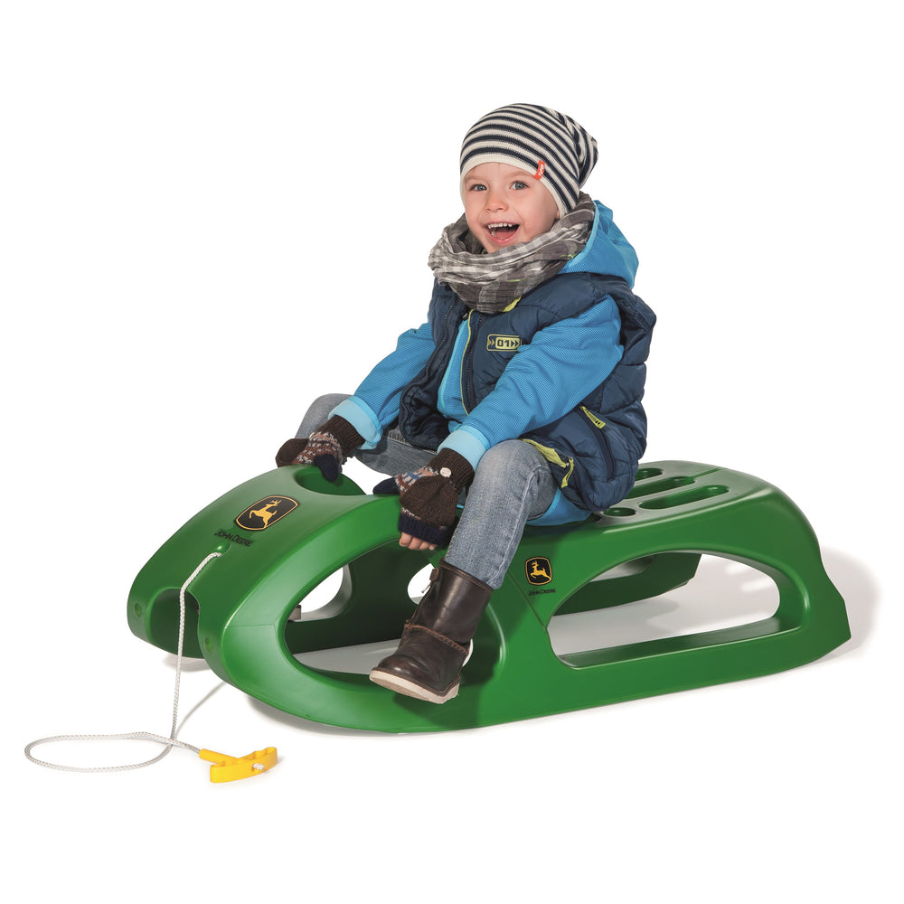 John Deere Snow Cruiser Sled By Rolly Toys with steel runners, nylon rope, and ergonomic handle, suitable for children and adults.