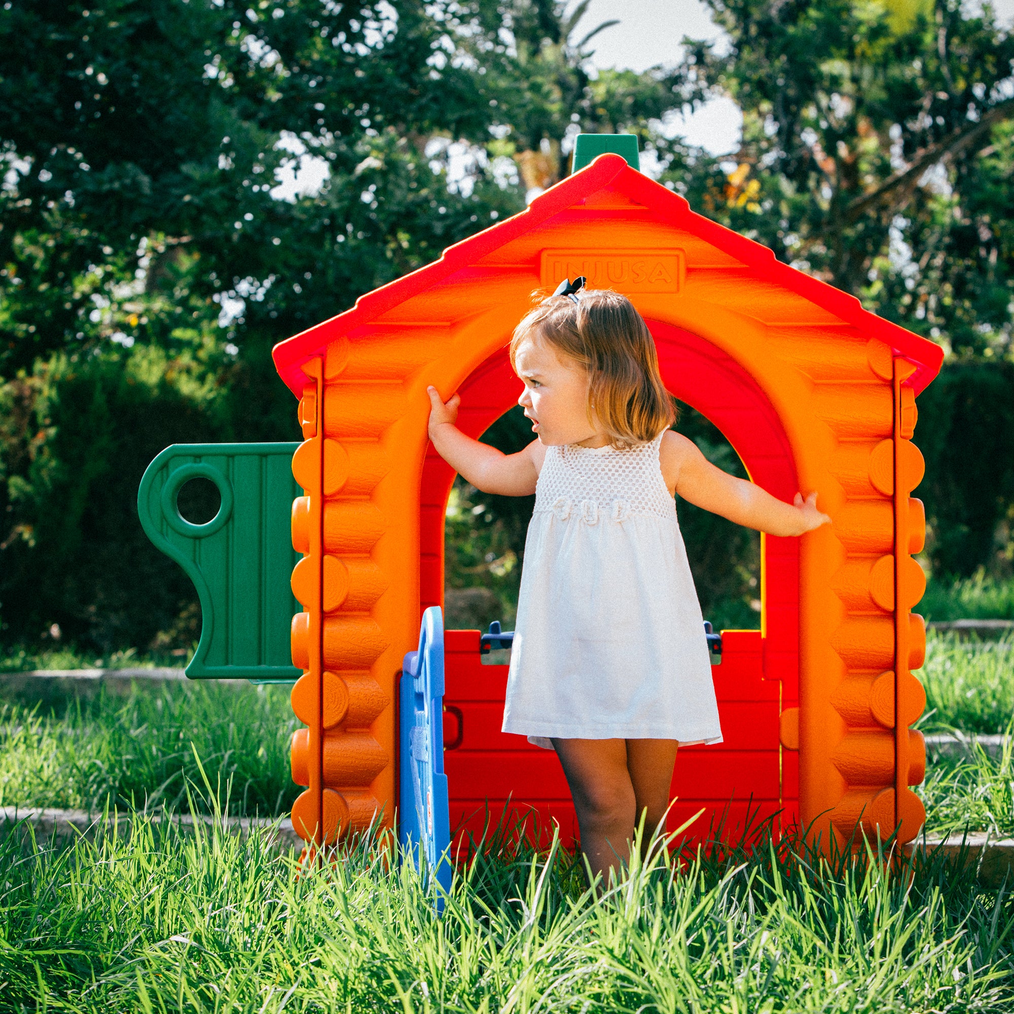 Lifestyle image of little girl playing in the INJUSA Resin Hut House.