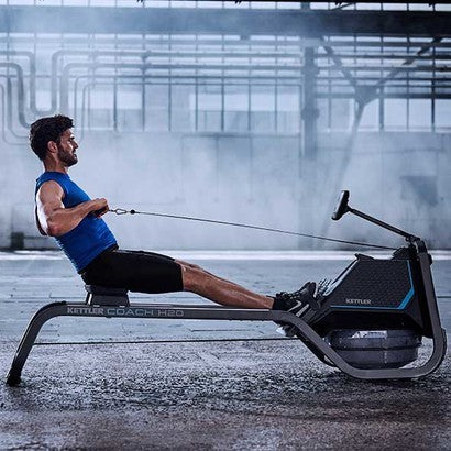 Lifestyle image of the Coach H20 rowing machine with a side profile of a man in an industrial setting using the rower.