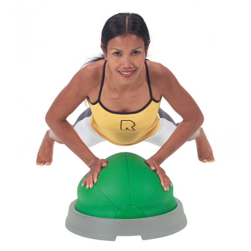 Woman exercising with soft green inflatable half ball Gymnic Core Balance for stability and coordination training