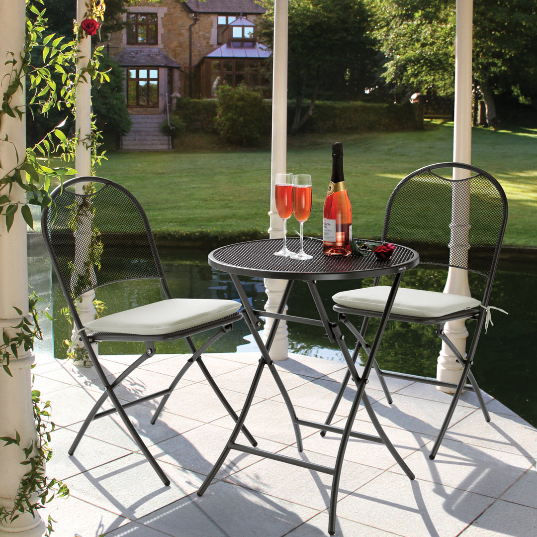 Cafe Napoli Wrought Iron 3-Piece Bistro Set with folding iron grey table and chairs on patio by water