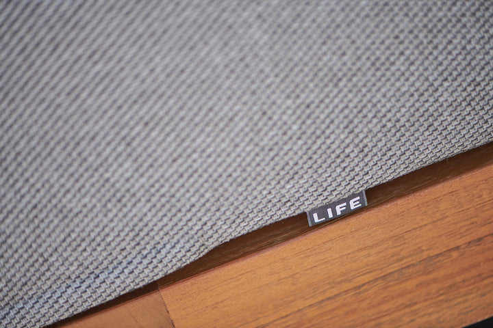Fitz Roy Teak Sofa close-up of teak wood frame and durable all-weather Natte Charcoal cushion fabric tag.