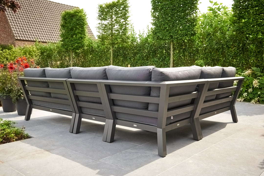 Timber Corner Conversation Set with charcoal cushions on lava frame in a sunny outdoor patio setting.