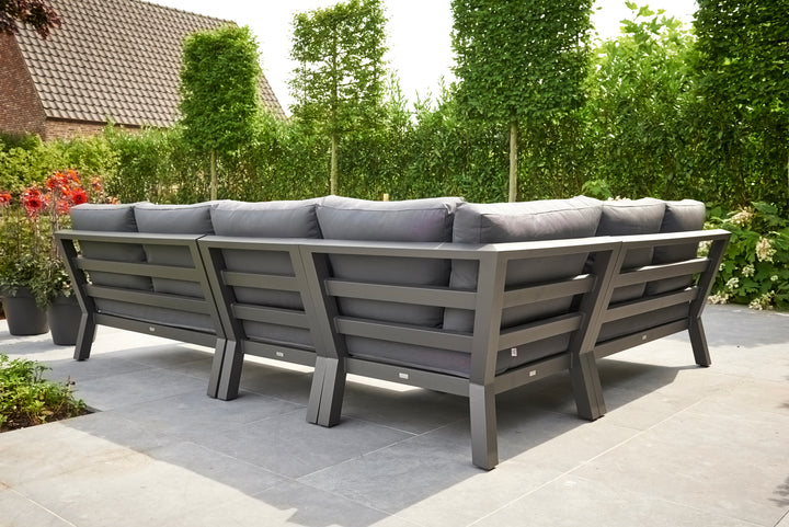 Timber Corner Conversation Set with charcoal cushions on lava frame in a sunny outdoor patio setting.
