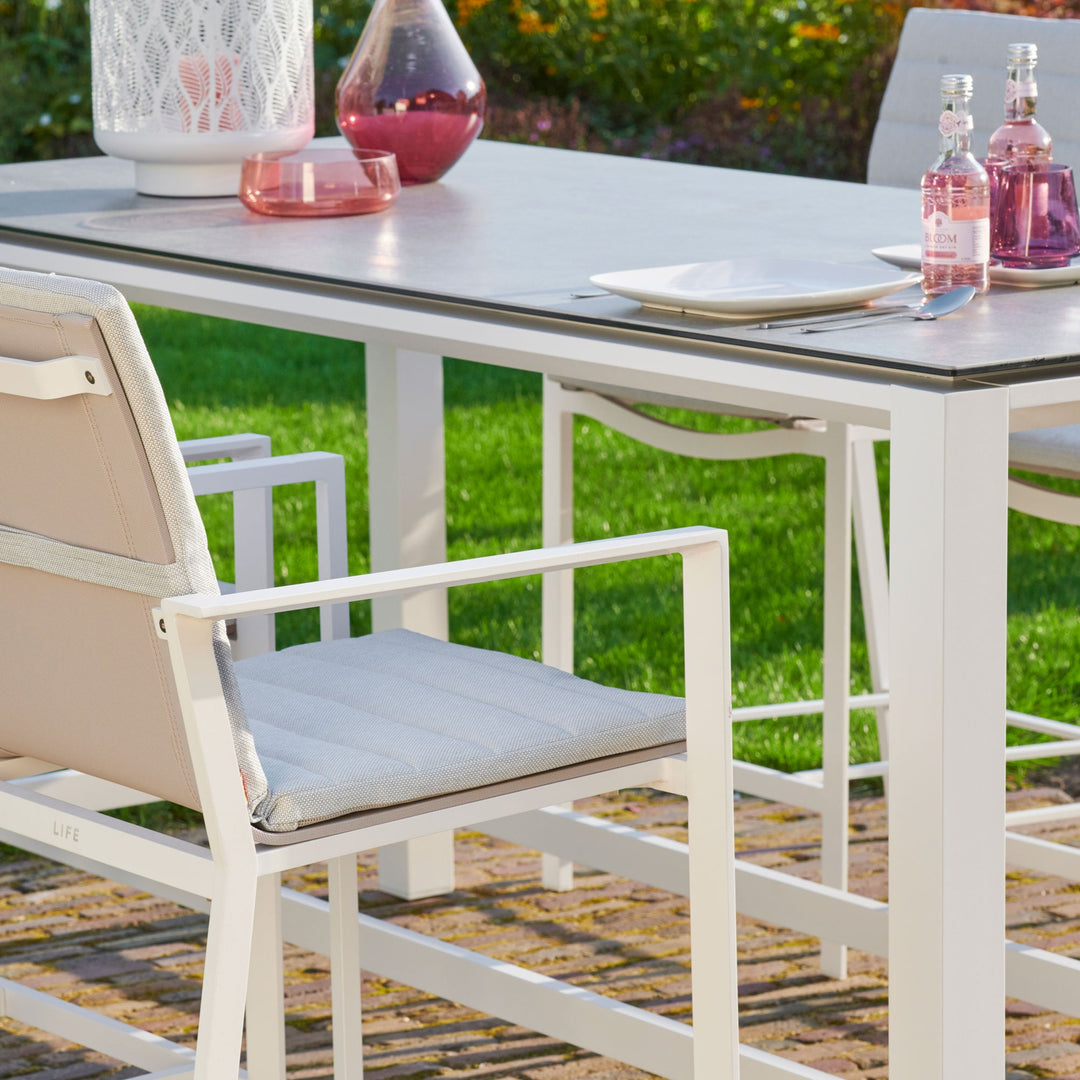 Primavera 5-Piece Bar Set - White  in a beautiful outdoor patio setting shows close up of the table frame and chair