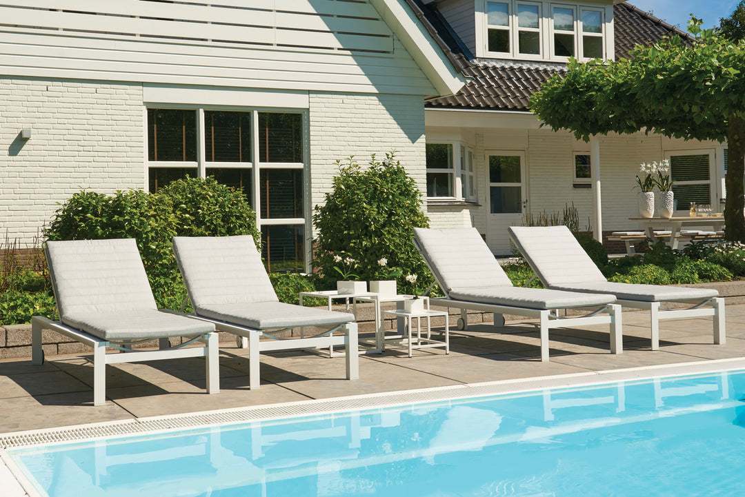 Delta Multi-Position Aluminum Loungers by the poolside with adjustable backs and white aluminum frames.