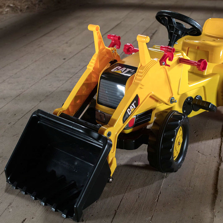 CAT Kid Tractor With Trailer pedal-powered yellow toy tractor with front loader and detachable trailer on wooden floor