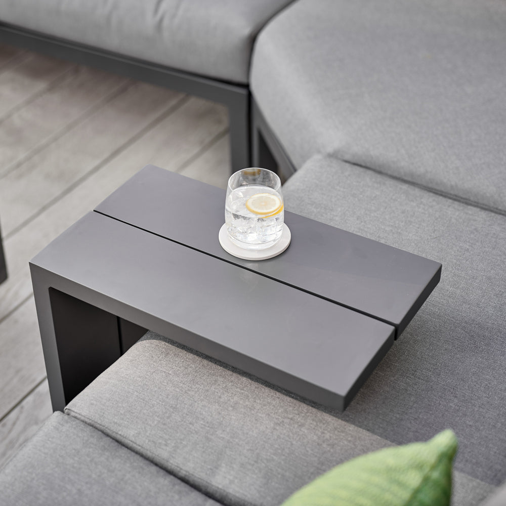 Elba Powder Coated Aluminum Side Table in charcoal with glass of water on gray outdoor sofa corner set.