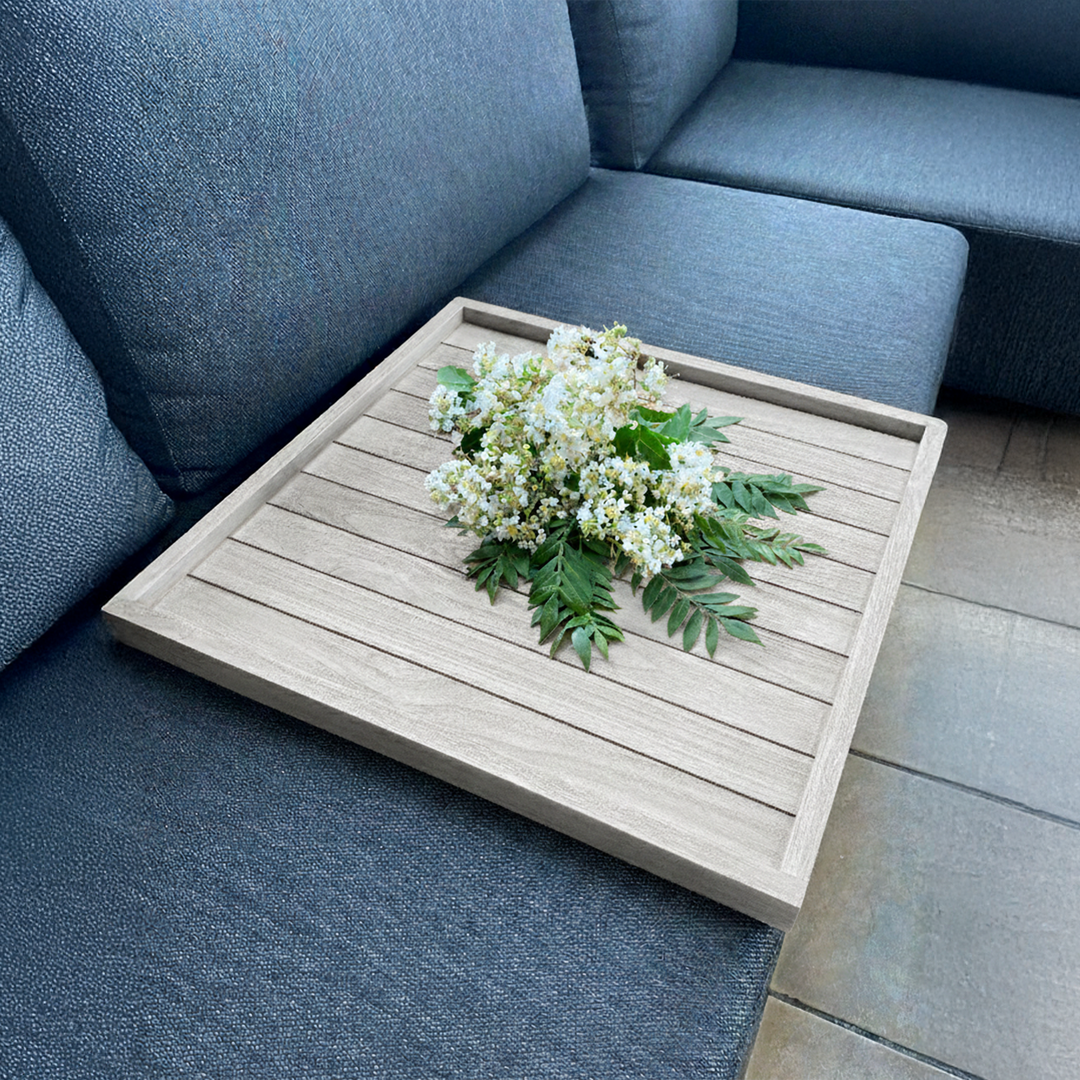 Balance Teak Serving Tray on outdoor sofa with flowers, showcasing sturdy Indonesian SVLK certified teak wood design.