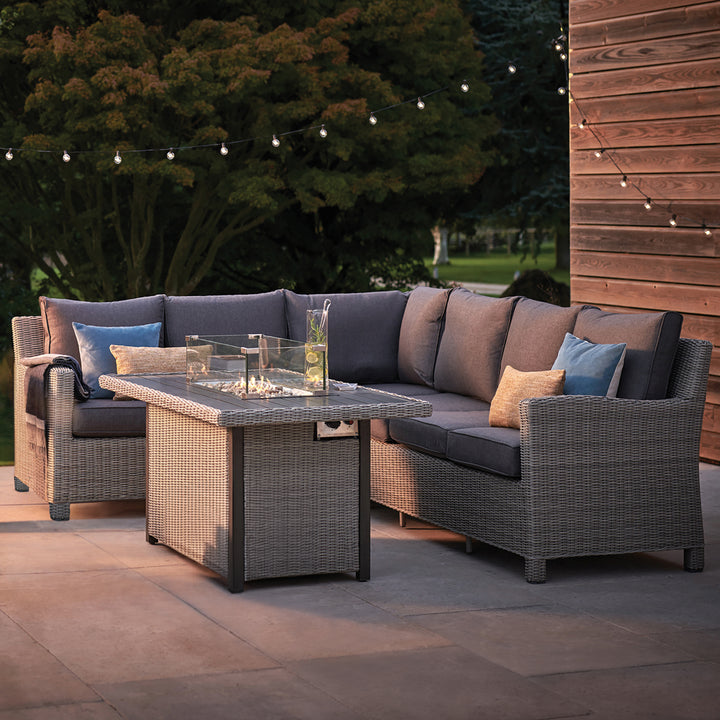 Palma Fire Table with wicker frame and cushioned seating, outdoor patio setup with fire pit and decorative pillows.