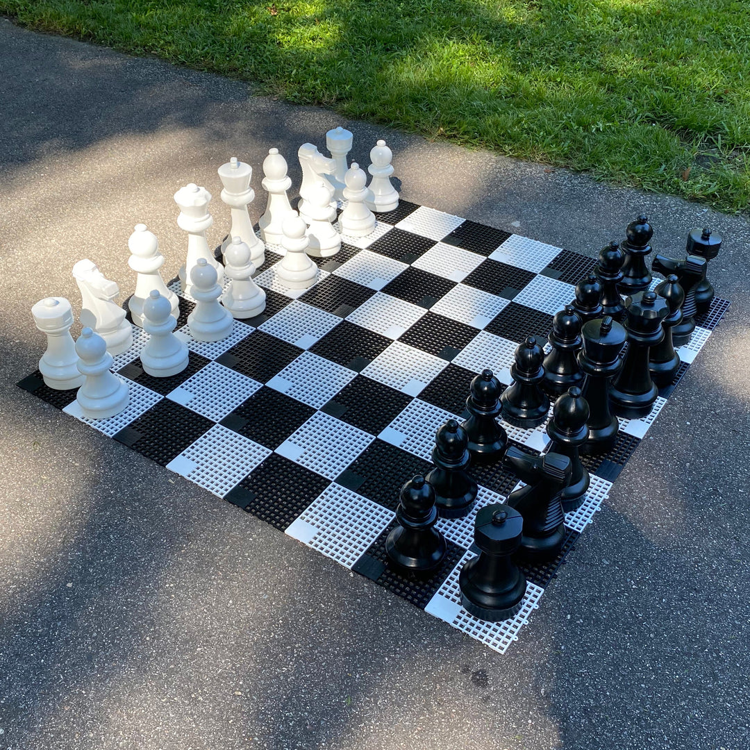 Mini - Giant Chess Set with large black and white resin pieces on outdoor checkered board in garden setting