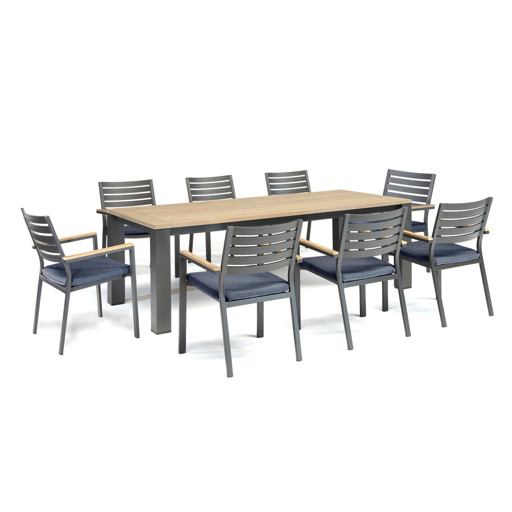 Elba 9-Piece Dining Set with teak tabletop, charcoal aluminum frame, and indigo cushioned stackable chairs.