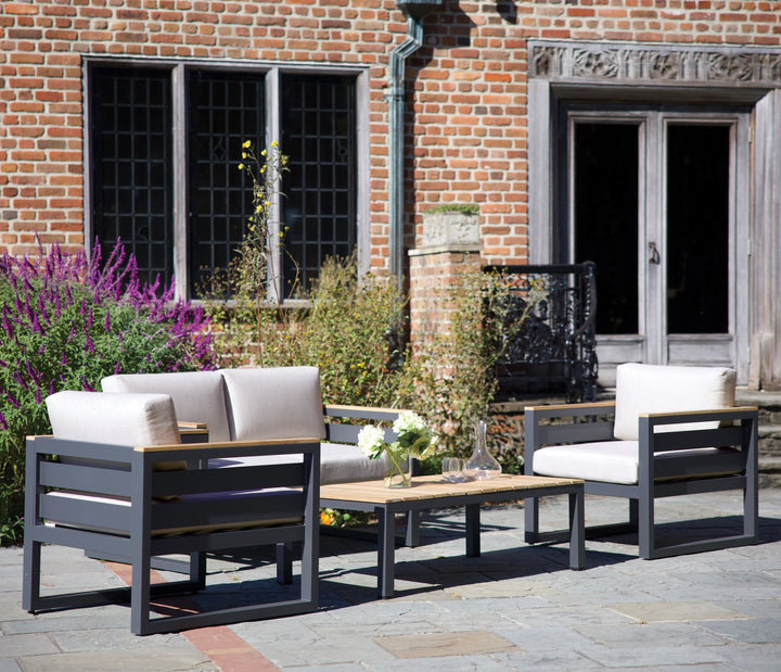 49x28-Inch Elba Comfort Rectangular Coffee Table With Teak Top in outdoor setting with charcoal frame and cushions
