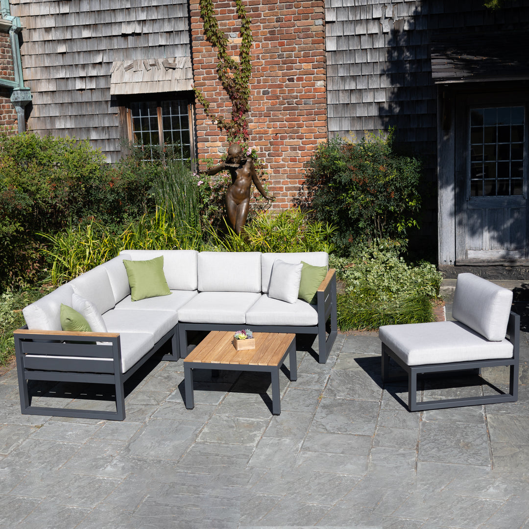 Elba Comfort Armless Chair with charcoal frame and cast silver cushions in outdoor patio setting.
