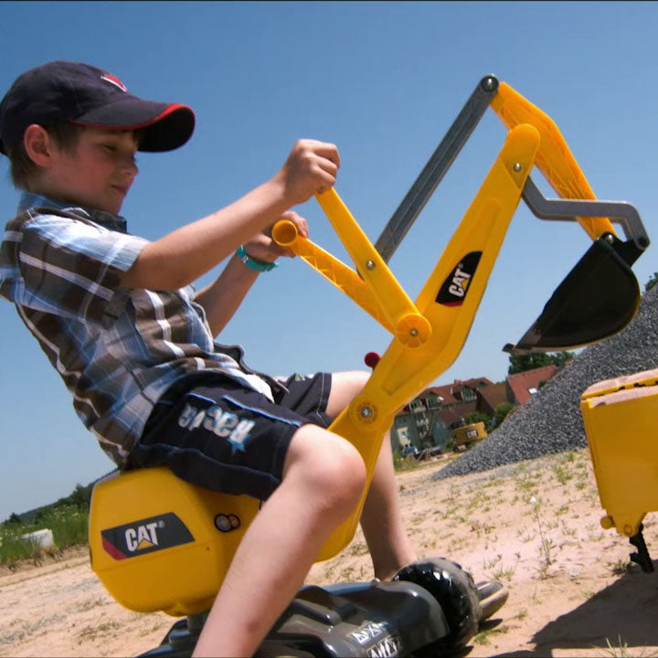 Lifestlye shot of child playing on the Caterpillar Digger outside.
