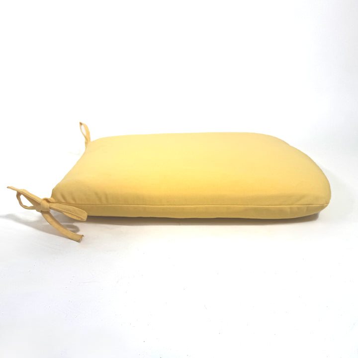 Yellow cushion with a tie on a white background