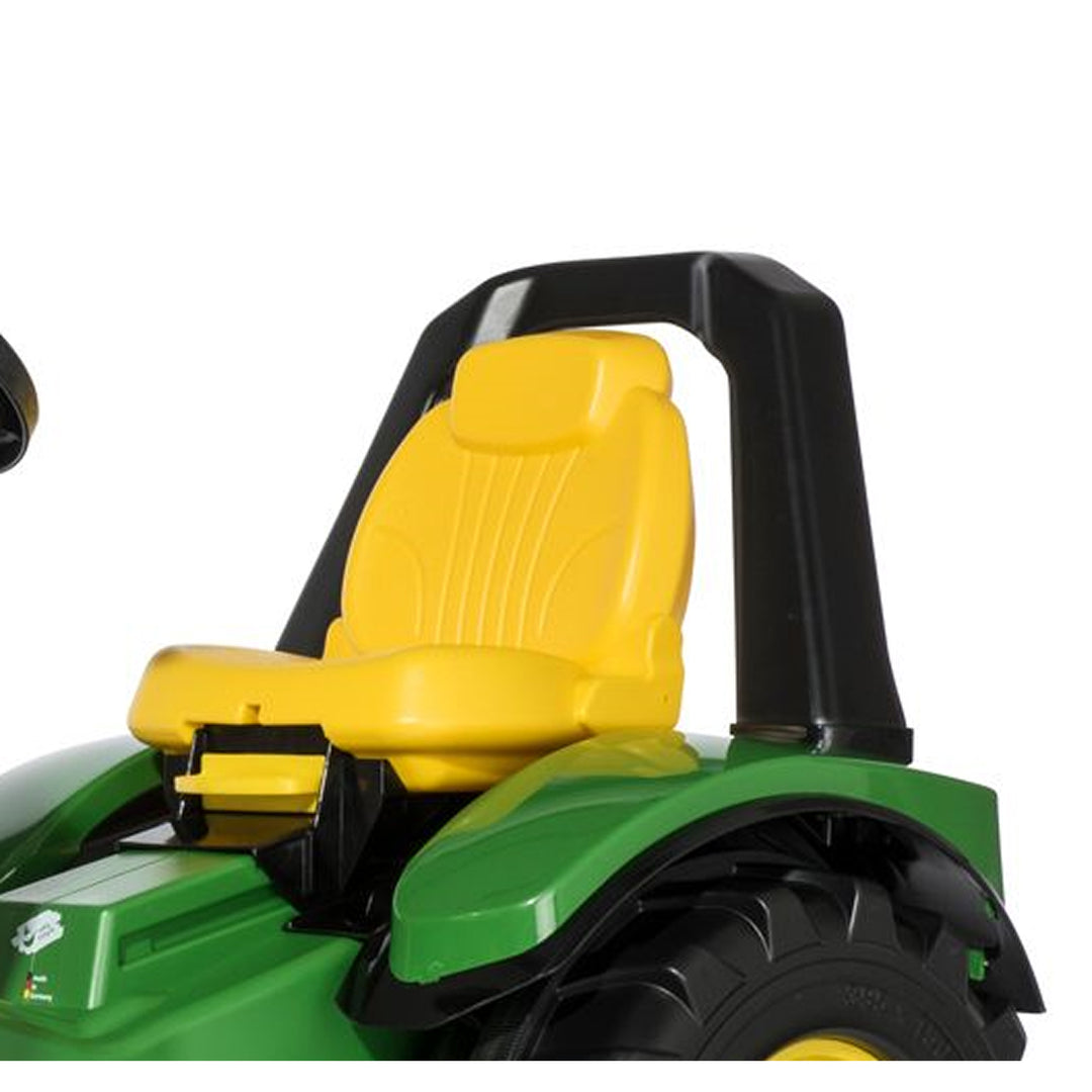 Close-up of yellow seat and black roll bar on green John Deere Premium X-Trac with Loader toy tractor.