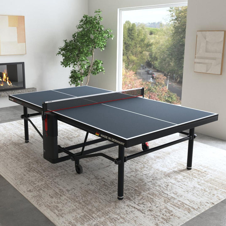 KETTLER Pro Indoor 15 Table Tennis Table set up indoors with black surface and sturdy steel frame in bright room.