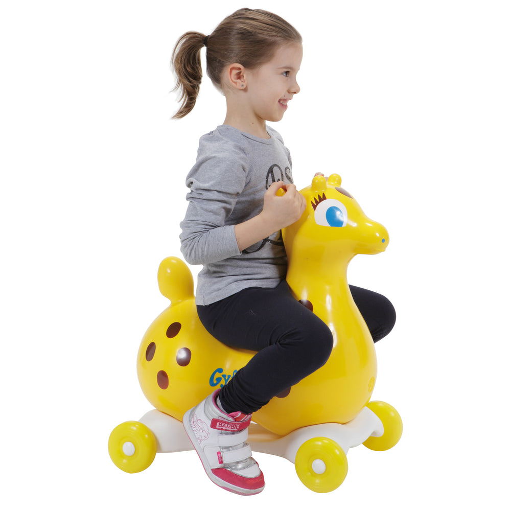 Child riding Gyffy The Giraffe Bounce Toy With Speedy Base, a yellow inflatable giraffe on a white wheeled base.