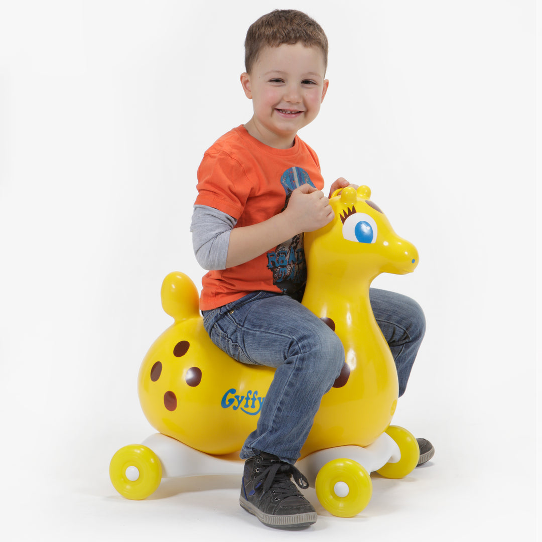 Child riding yellow Gyffy The Giraffe Bounce Toy With Speedy Base, promoting balance and active playtime.