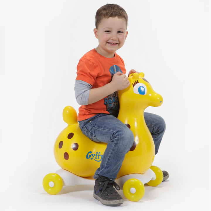Child riding yellow Gyffy The Giraffe Bounce Toy With Speedy Base, promoting balance and active playtime.