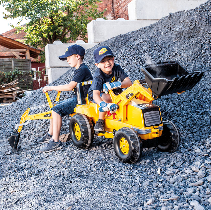 CAT Front Loader With Backhoe Pedal Tractor with two kids playing outdoors on gravel pile in sunny setting