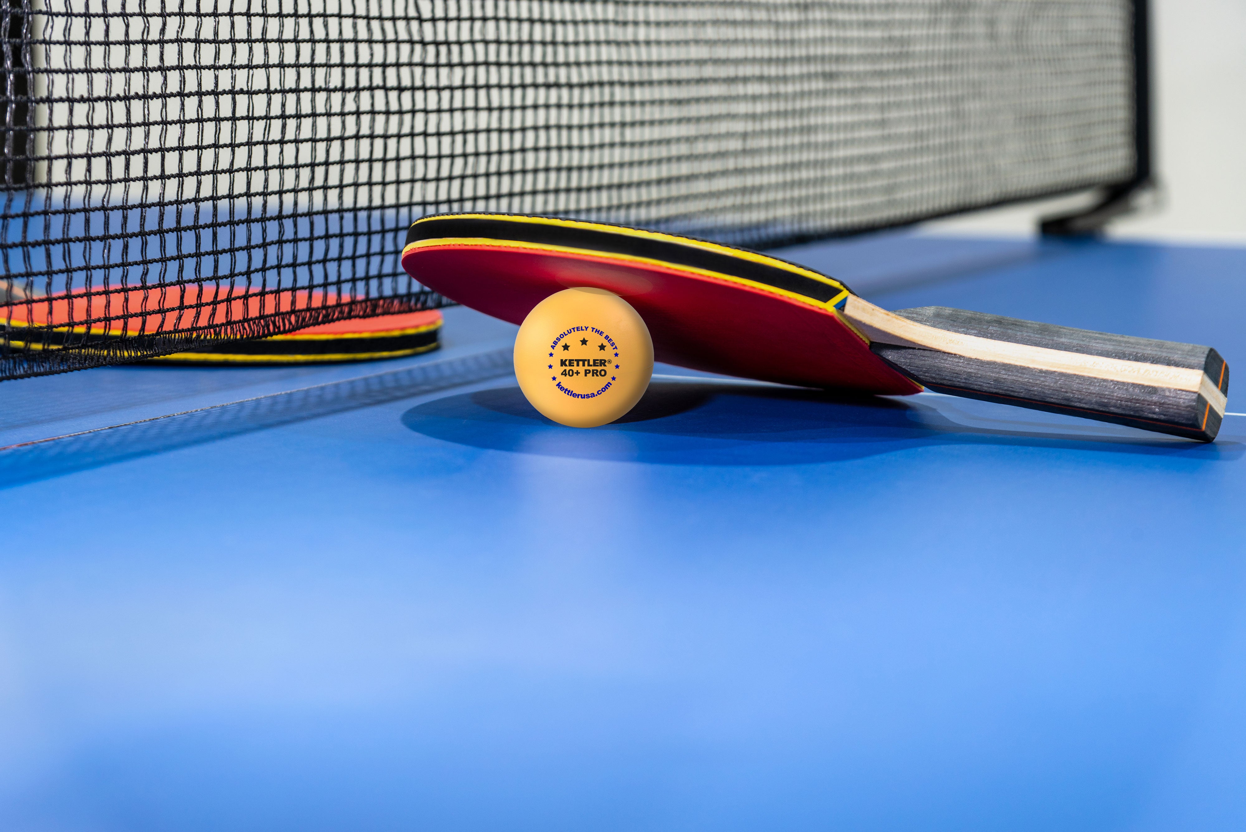 Carbon racket with 3 star orange ball close up