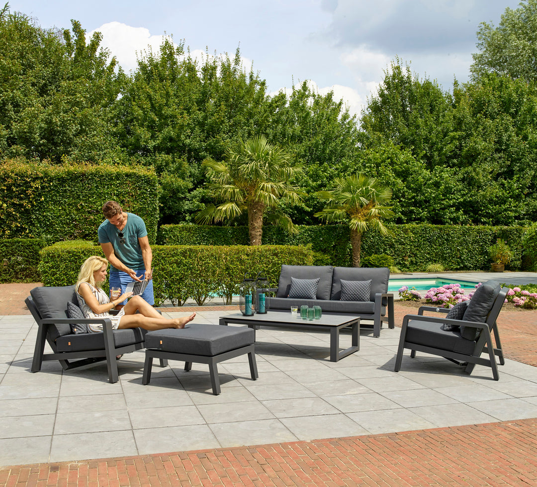 Boston Select Reclining Lounge Chair with charcoal cushions and lightweight aluminum frame in outdoor patio setting.