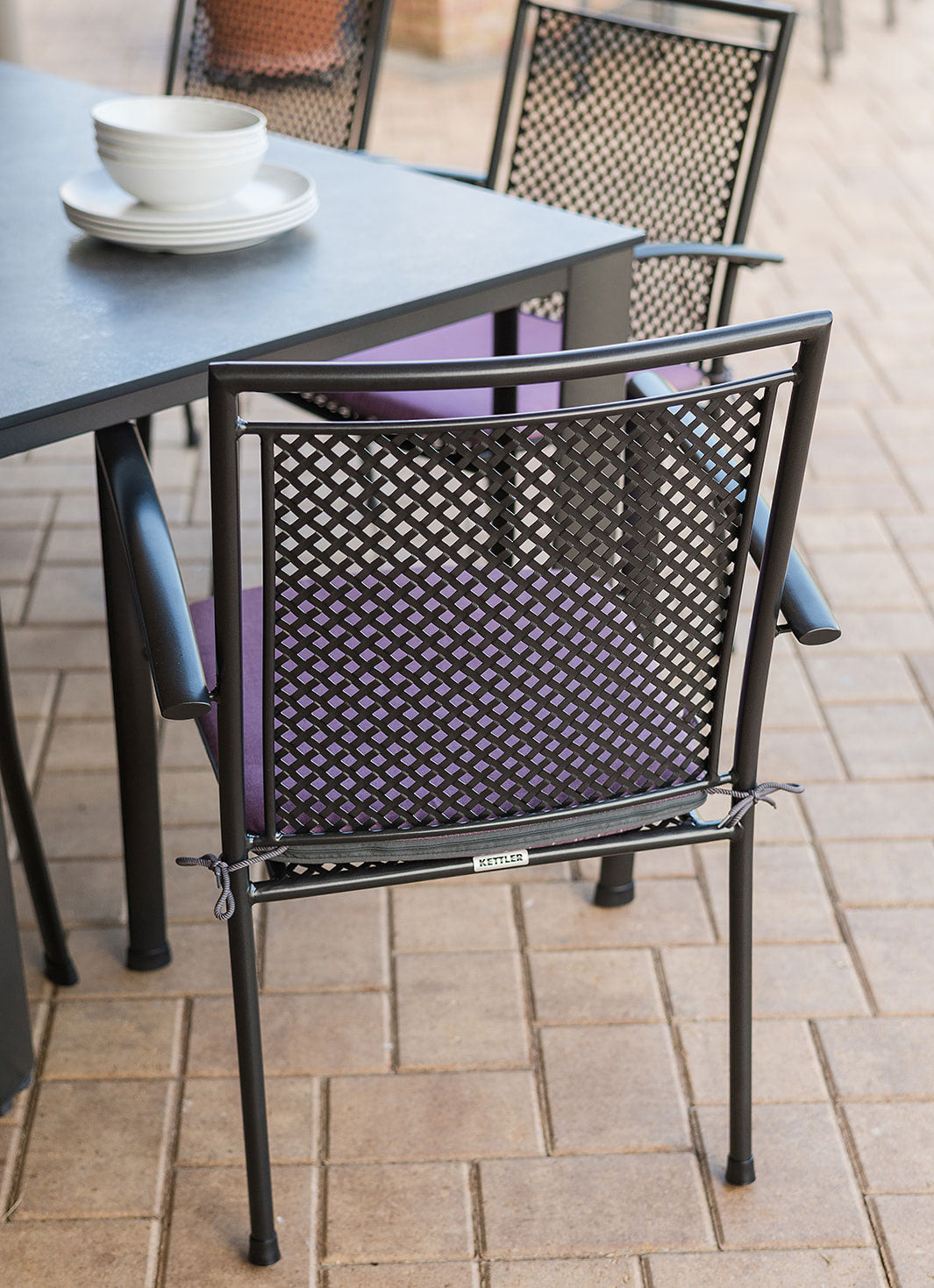 Reno 7-Piece Dining Set with wrought iron chairs and spacious HPL table in iron gray for outdoor use.