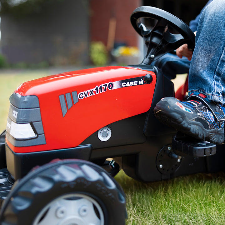 Case IH Tractor With Trailer kid's red pedal tractor with detailed hood and large tires on grass.