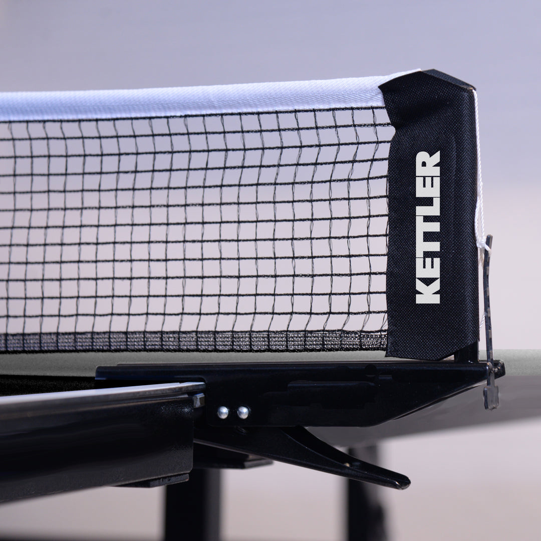 Close-up of KETTLER Indoor Conversion Top showing the net and clip attached to a billiard table.