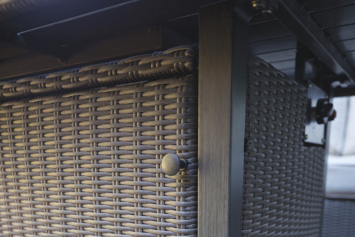 Close-up of the woven rattan texture and side panel of the Palma Fire Table in outdoor setting.