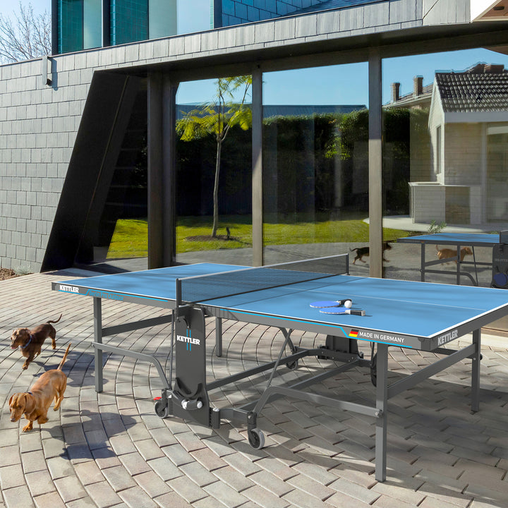 Berlin Pro Outdoor Table Tennis Table 4-Player Bundle set up outside with paddles and balls on table surface