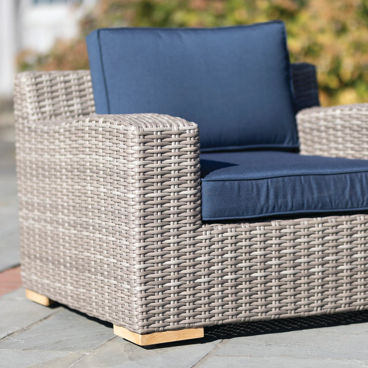 Palma Luxe Lounge Set close-up of handwoven oyster weave chair with navy blue cushions and teak feet outdoors.