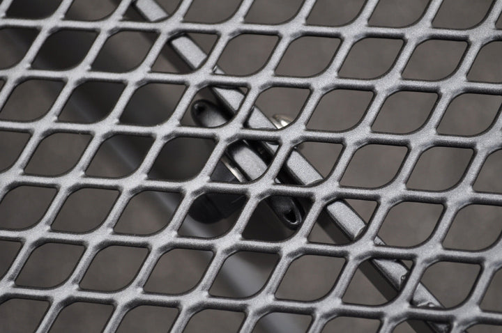 Close-up of iron grey mesh tabletop detail of Pilano Woven 5-Piece Wrought Iron Dining Set.