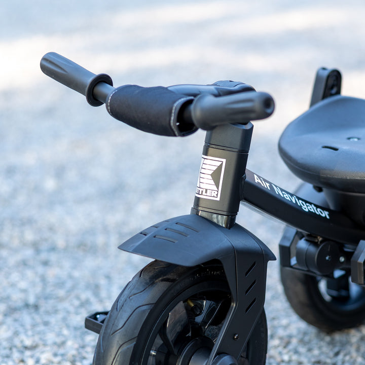 KETTLER Air Navigator 6-in-1 Tricycle close-up of front wheel and handlebar with black frame and seat.