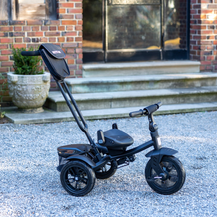 KETTLER Air Navigator 6-in-1 Tricycle in black with adjustable parent handle, storage bag, and reclining seat outdoors.