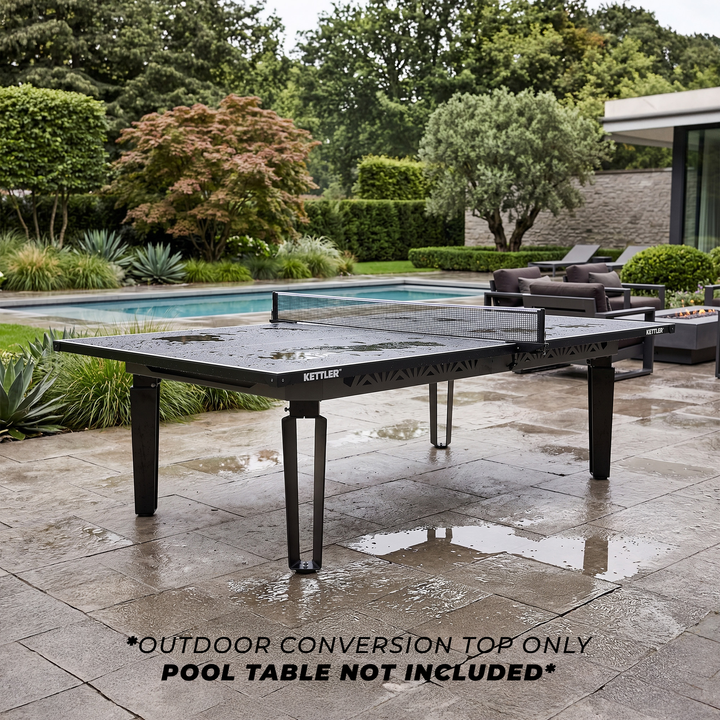 KETTLER Outdoor Conversion Top fitted to a table tennis table beside a swimming pool in a landscaped garden