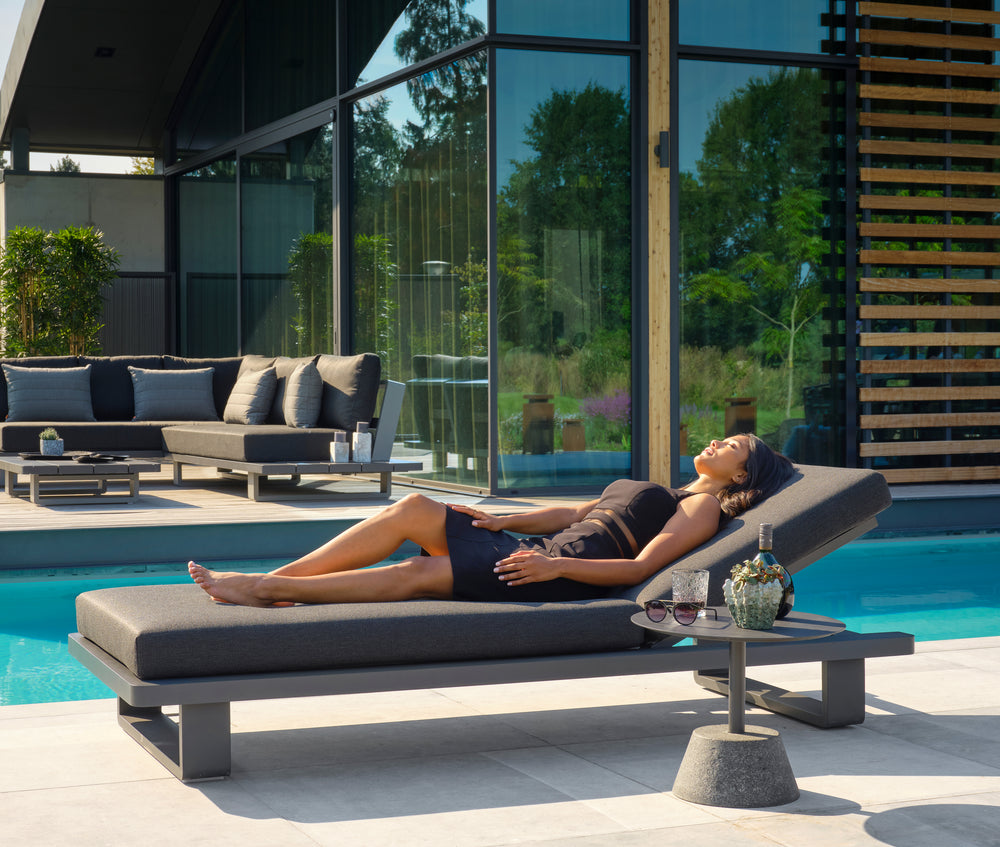 Fitz Roy Aluminum Lounger with charcoal cushions by poolside featuring reclining back and durable lightweight lava aluminum frame.