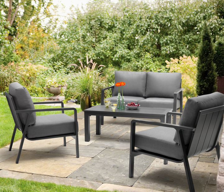 Paros Aluminum Lounge Set with charcoal frame and cast slate cushions in a garden patio setting with table and seating.