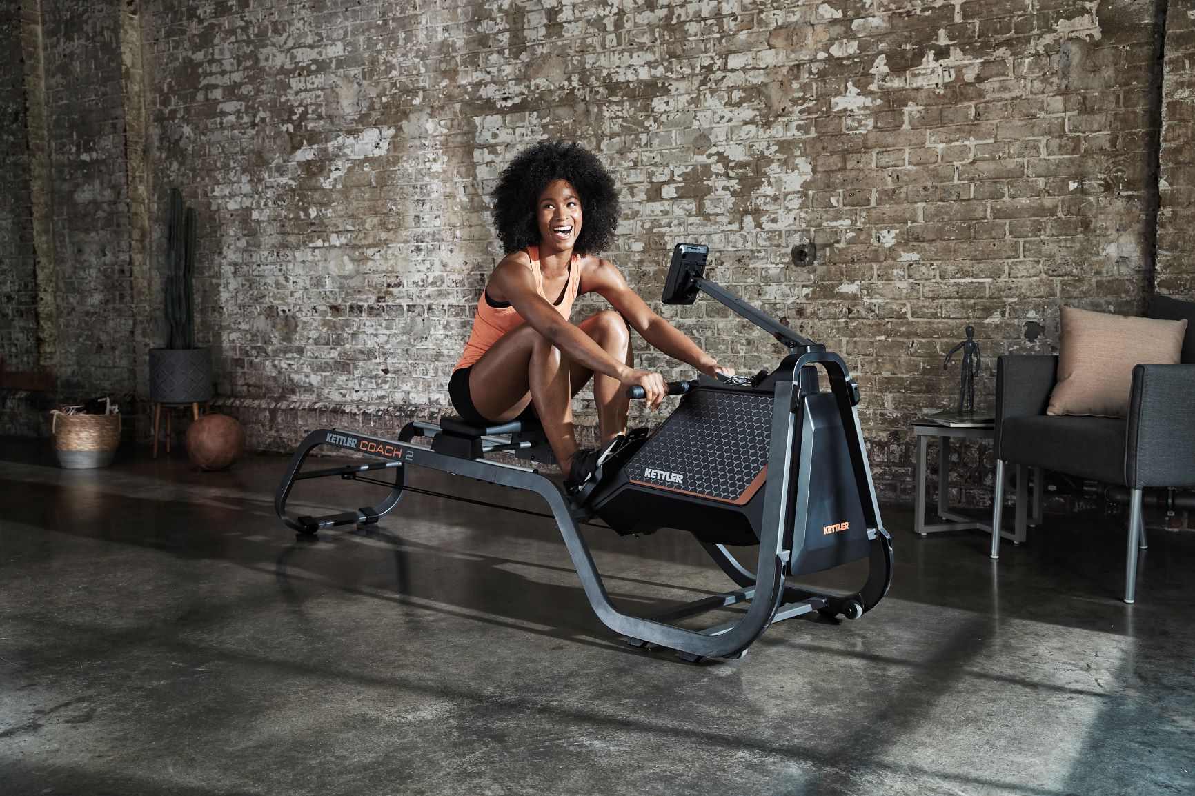 Lifestyle image of the Coach 2 Rowing Machine in use by smiling model.